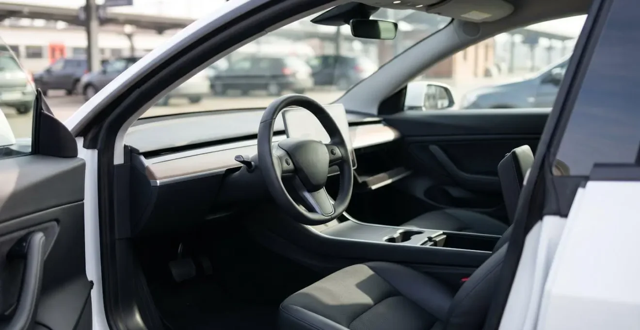 Vue intérieure d'une voiture avec habitacle complètement vide et rangements ouverts montrant l'absence d'objets