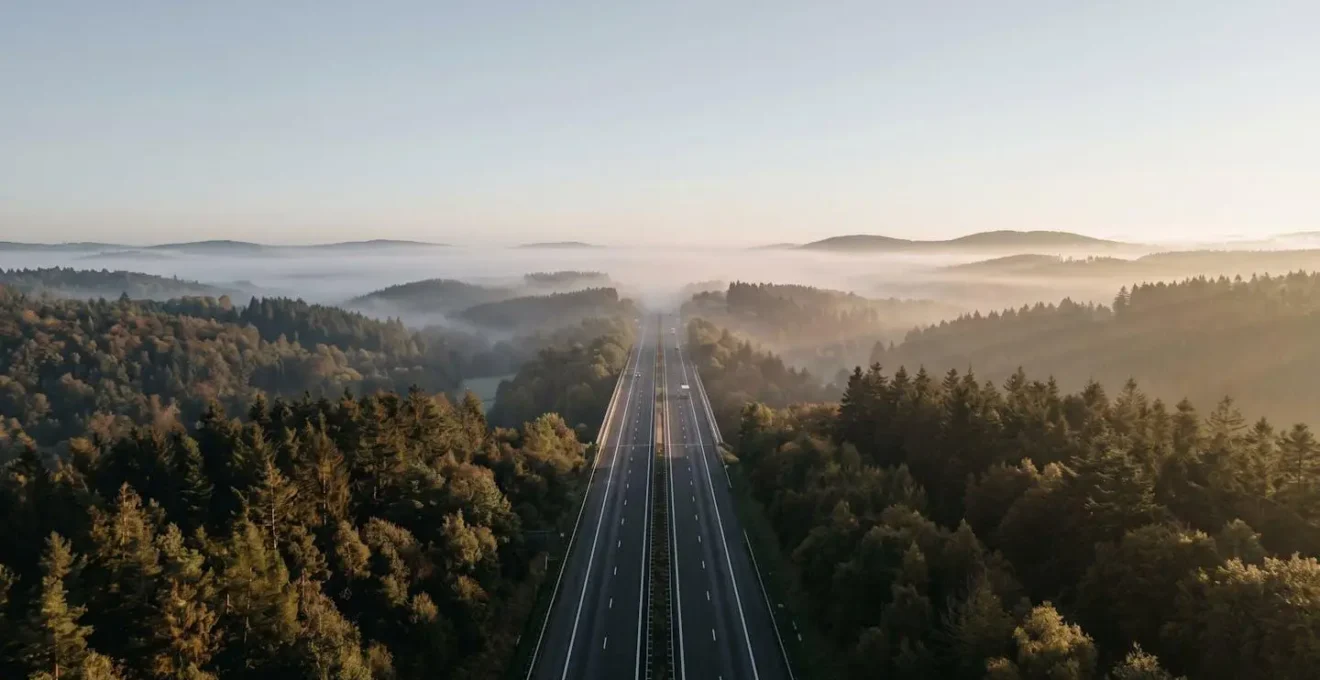 Vue panoramique de l'autoroute E411 traversant les Ardennes belges avec effet de profondeur
